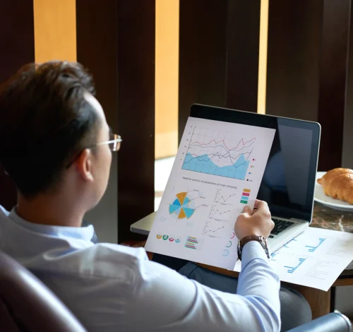 rear-view-man-seated-armchair-cafe-analyzing-diagrams-charts-before-presentation (1)